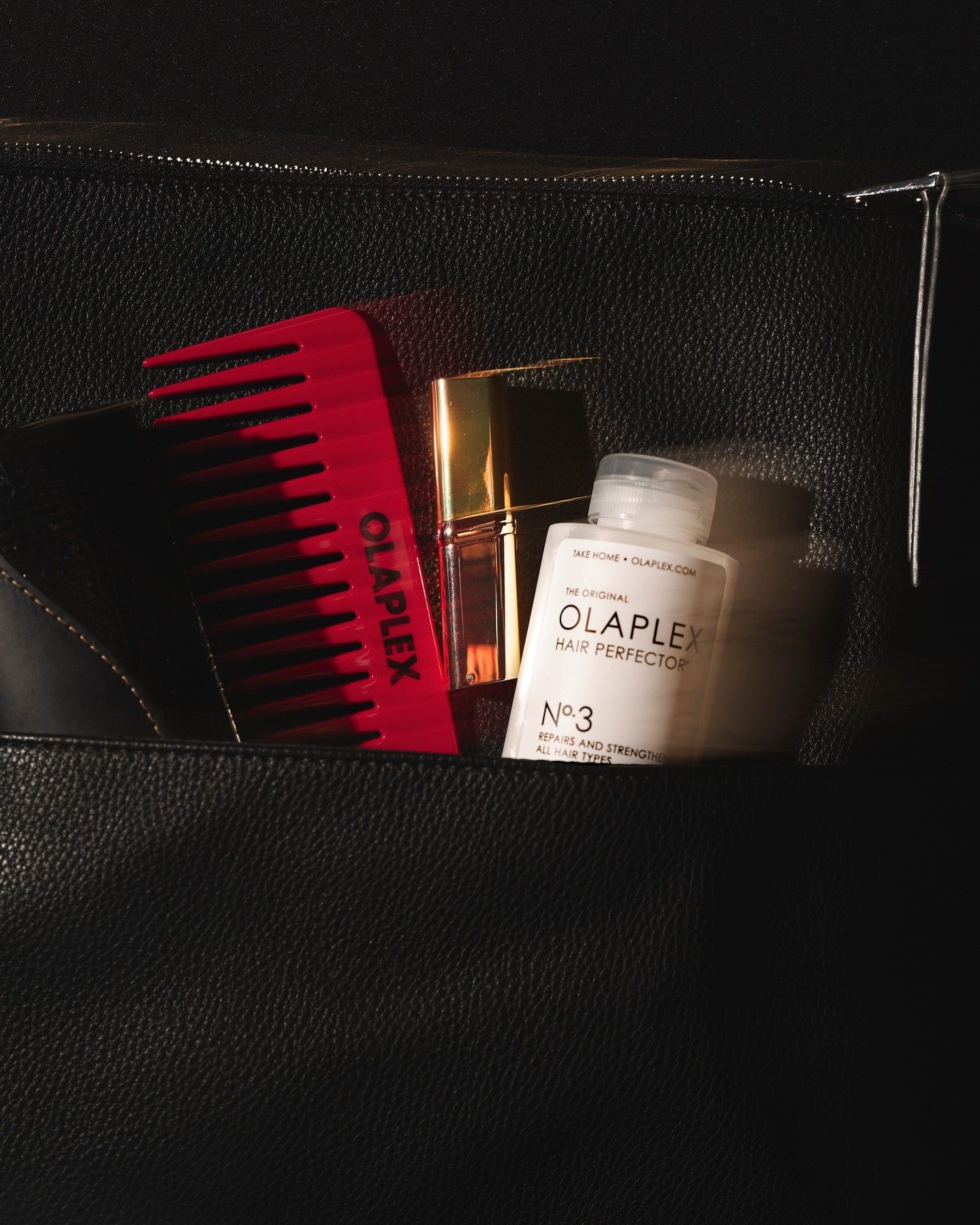 Branded merchandise created by Twelve for OLAPLEX; red branded comb