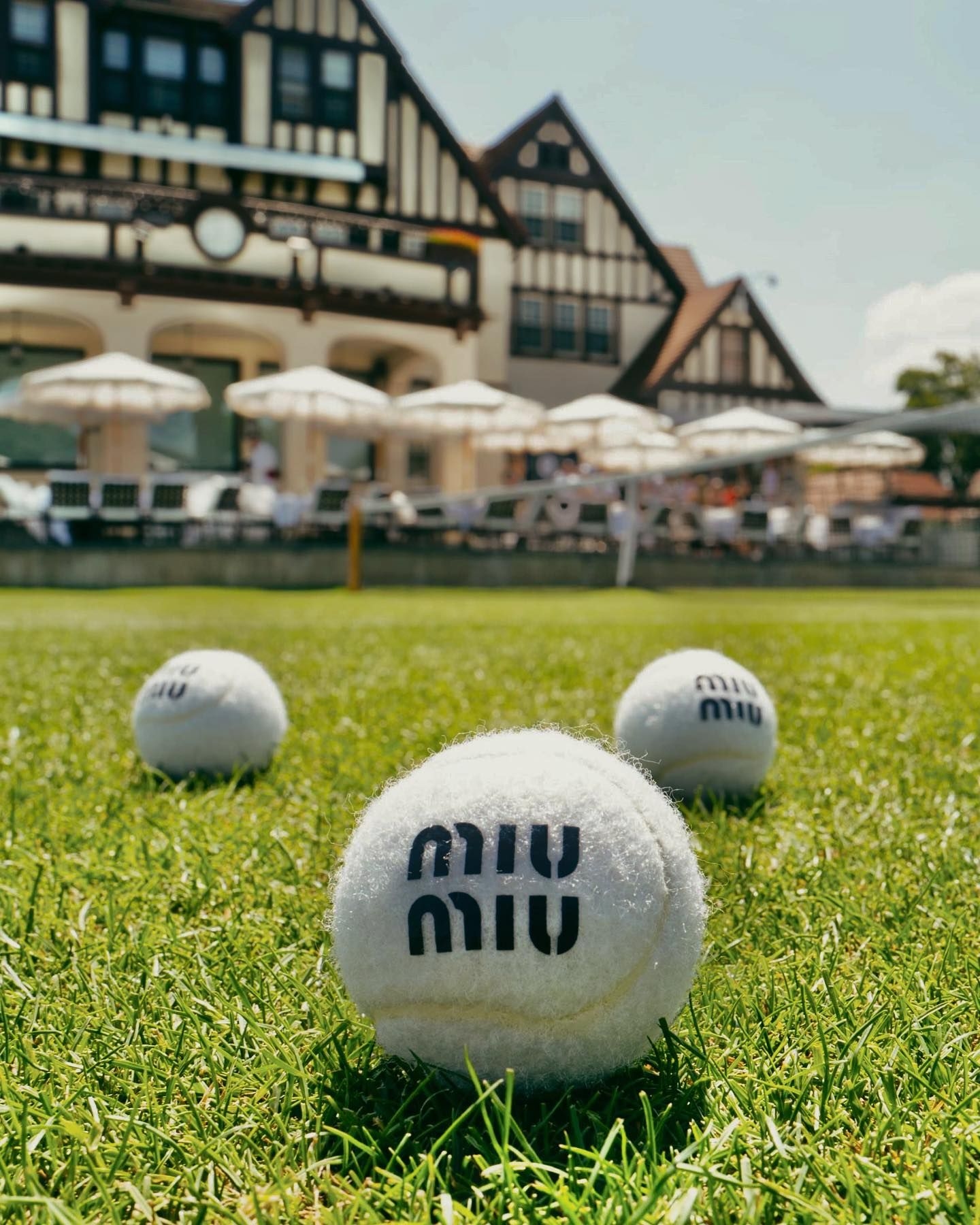 Branded merchandise created by Twelve for Miu Miu; white tennis balls on a grass background