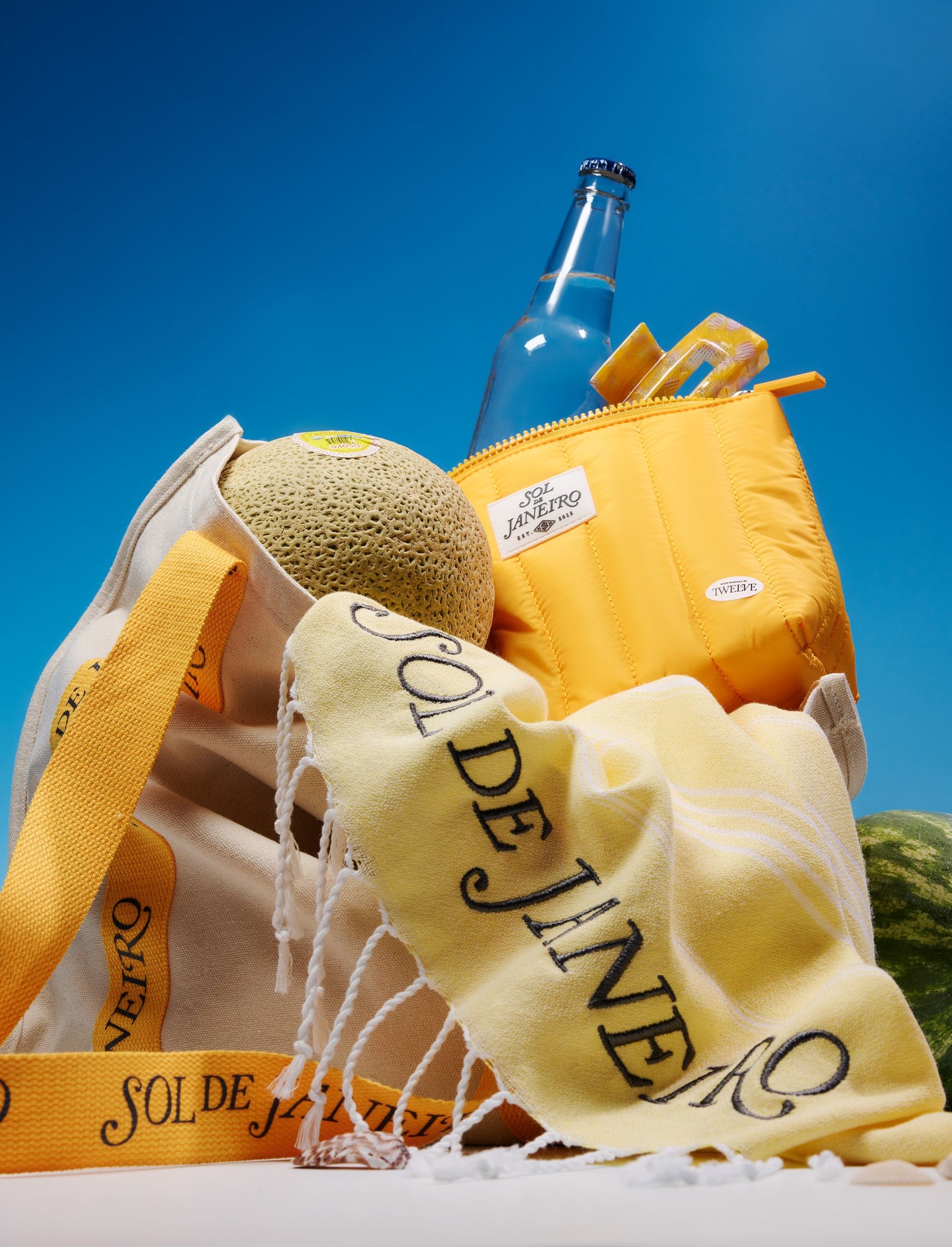 Branded merchandise created by Twelve for Sol De Janeiro; yellow branded canvas tote bag, yellow branded cooler bag, yellow branded towel