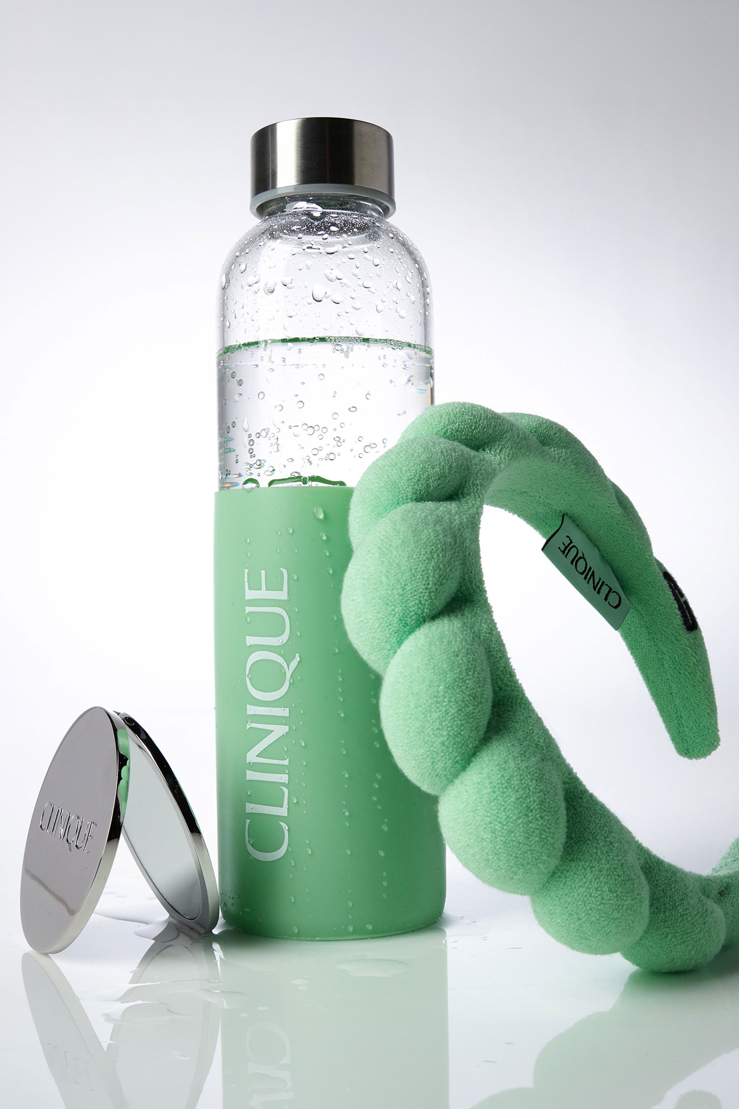 Clinique custom wellness accessories including water bottle, compact, and headband